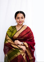 Woman in a traditional maroon and green Cotton Silk Maheshwari saree.