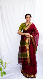 Woman in a traditional maroon and green Cotton Silk Maheshwari saree.